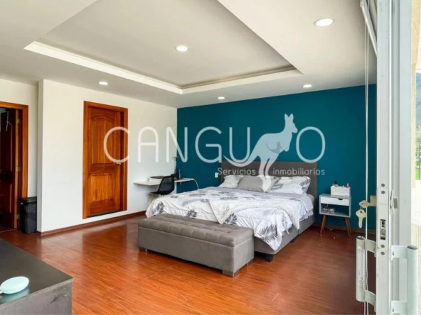 Dormitorio master con walk-in closet y acceso exclusivo a terraza privada en la casa de venta en Pusuquí.