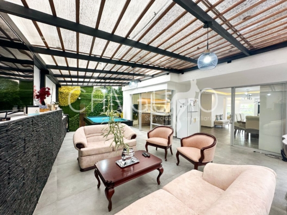 Patio cubierto con pérgola y área de BBQ.