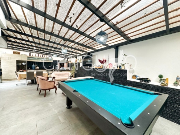 Patio cubierto con pérgola y área de BBQ.