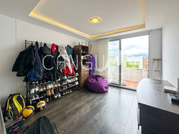 Sala de TV en planta alta con salida al balcón.