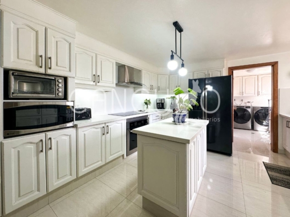 Cocina cerrada con isla y mesones de cuarzo