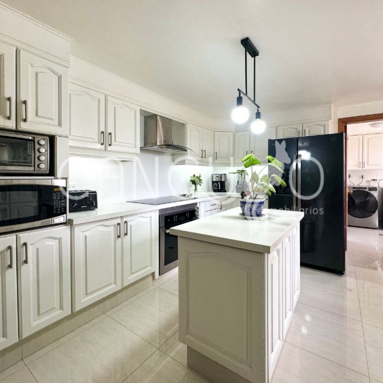 Cocina cerrada con isla y mesones de cuarzo