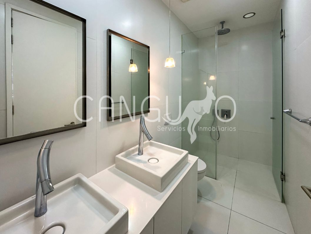 Baño con cortinas de vidrio templado doble lavamanos